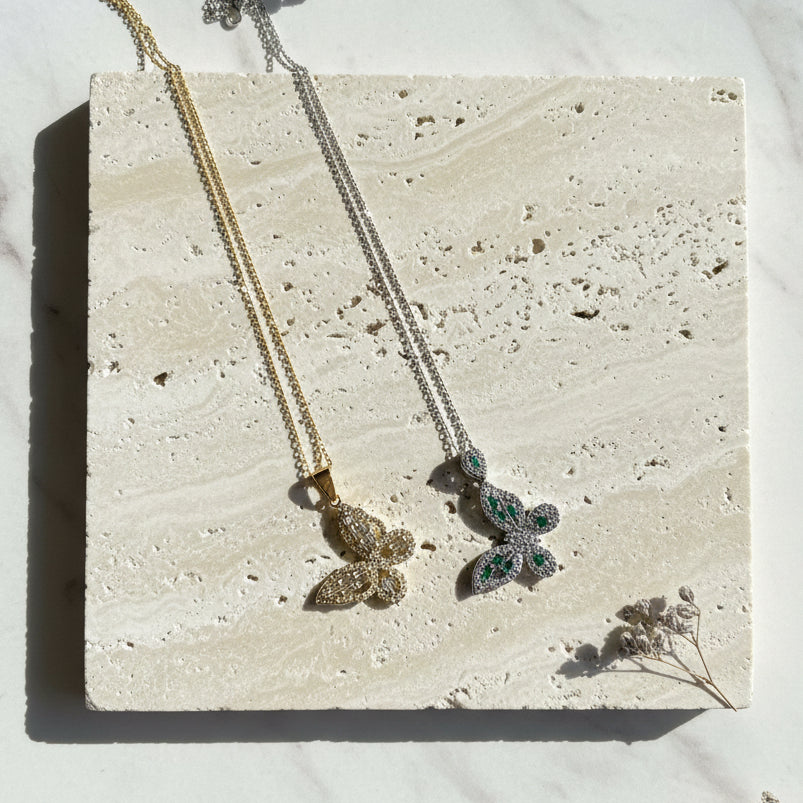 Crystal butterfly pendant necklaces shown in gold and silver plating — spirit animal jewelry