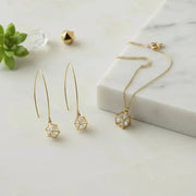 Gold cube-shaped earrings and necklace on a white background