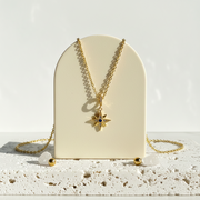 Crystal star necklace with a blue crystal centre hanging on a gold chain — celestial jewelry