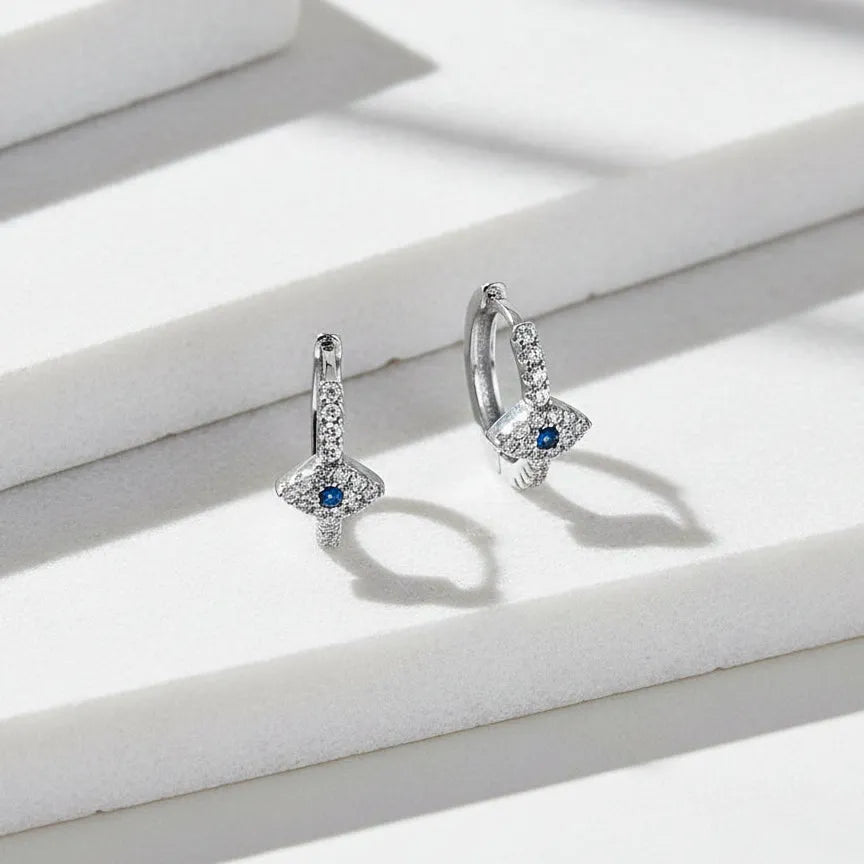 Pair of silver earrings with gemstones on a white background