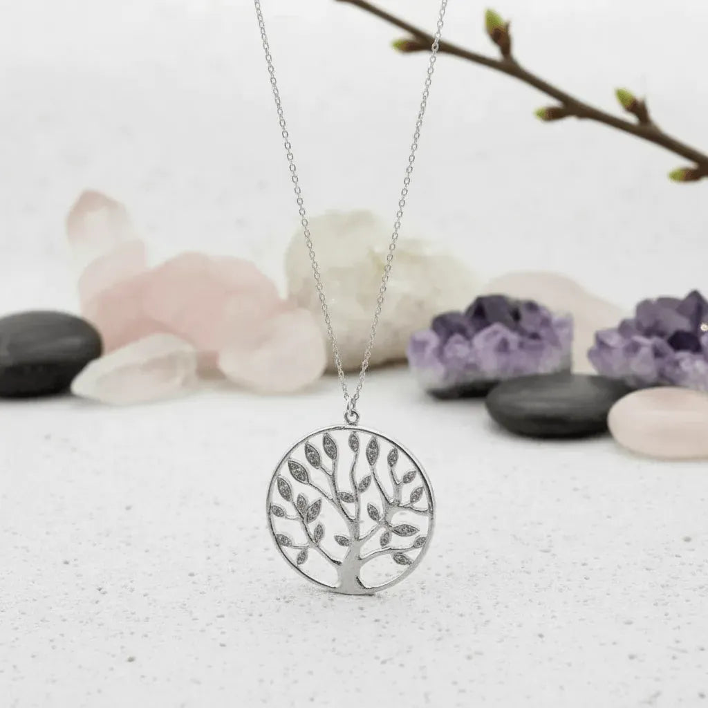 silver tree-shaped pendant necklace on a light background