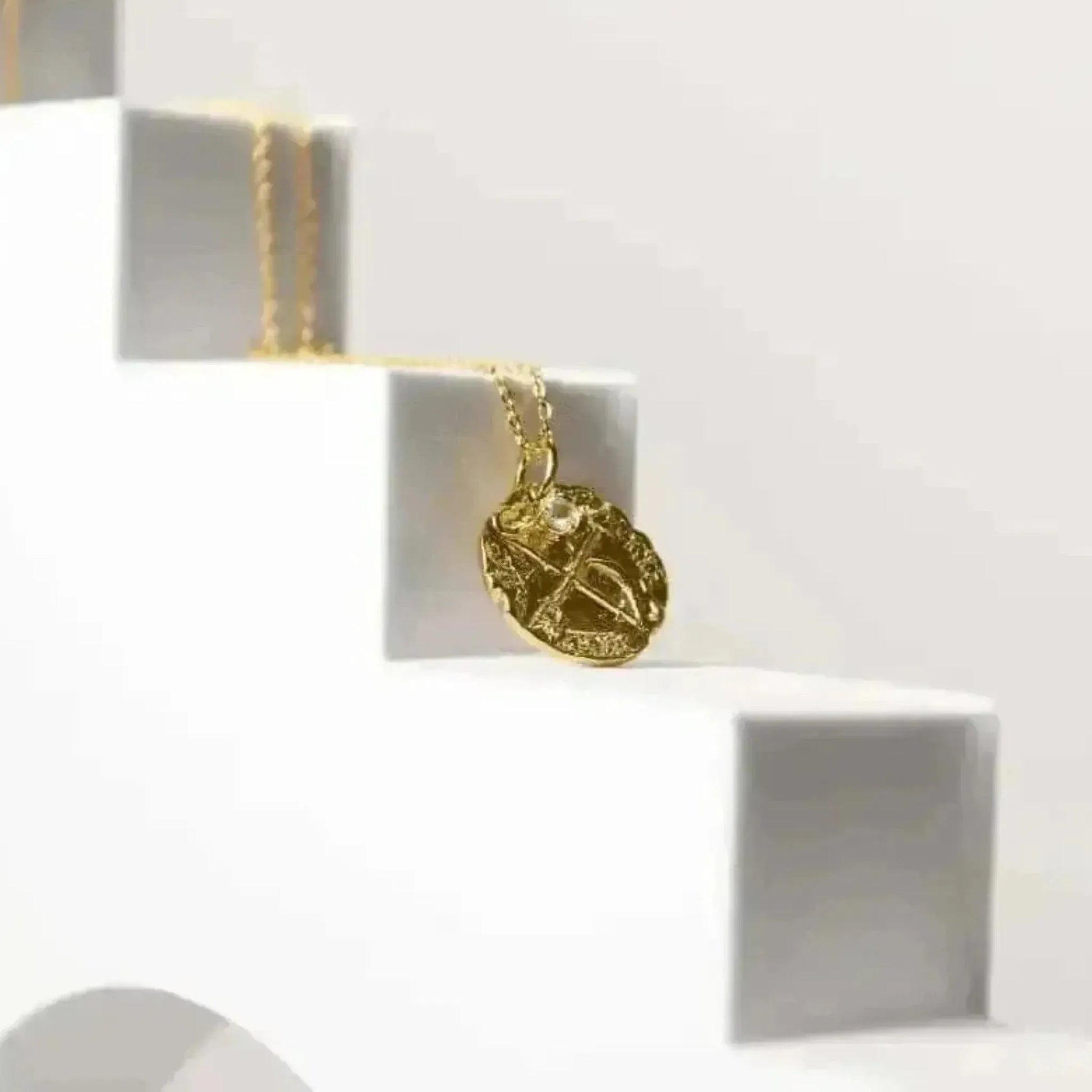 Gold necklace with a pendant on a white background