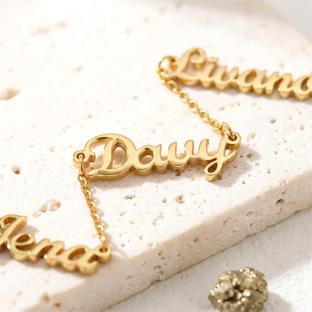 Close-up of gold three-name necklace showing the linked script nameplates