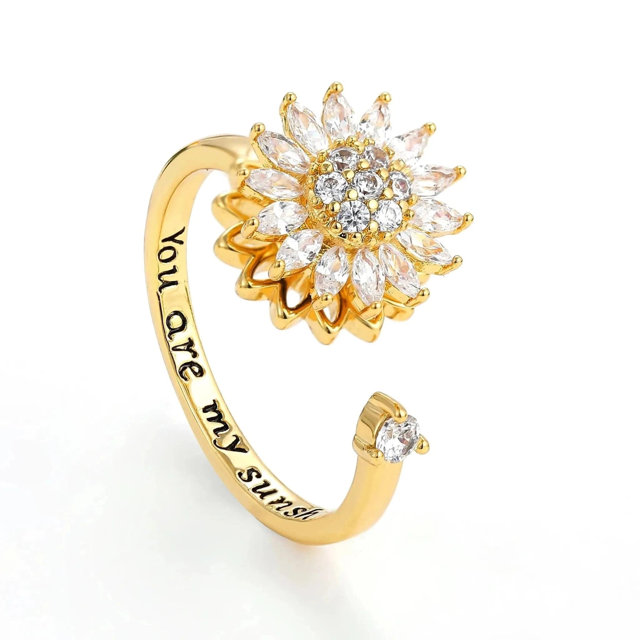 Gold ring with diamond-like stones and 'You are my sunshine' engraving on a white background