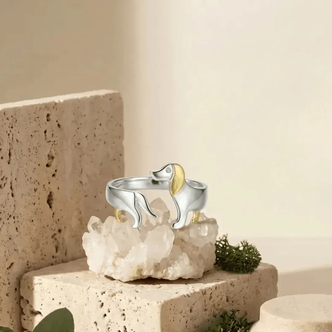 Silver ring with a gold accent on a decorative stone surface with a neutral background