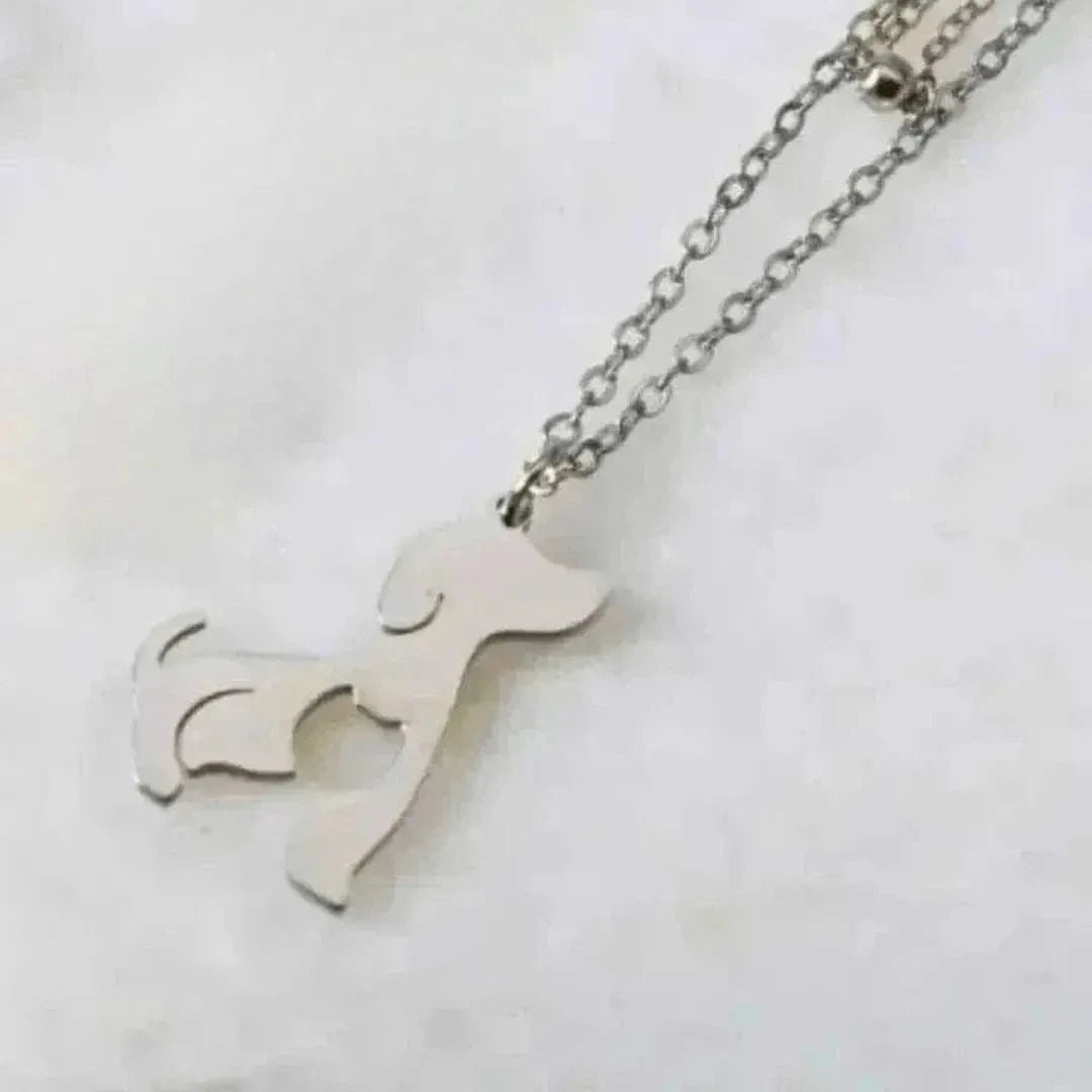 Silver dog-shaped pendant on a chain against a white background