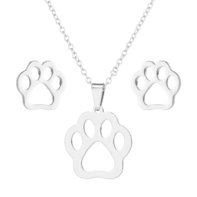 Silver paw print necklace and earrings set on a white background with 