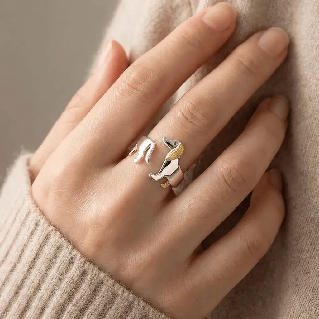 Hand wearing two rings with a neutral background