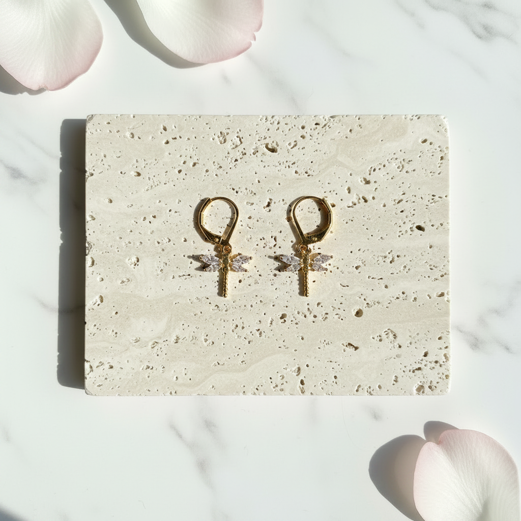 Gold crystal dragonfly leverback earrings flat lay — spirit animal jewelry for transformation