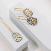 Jewelry set with gold and silver earrings on a white surface