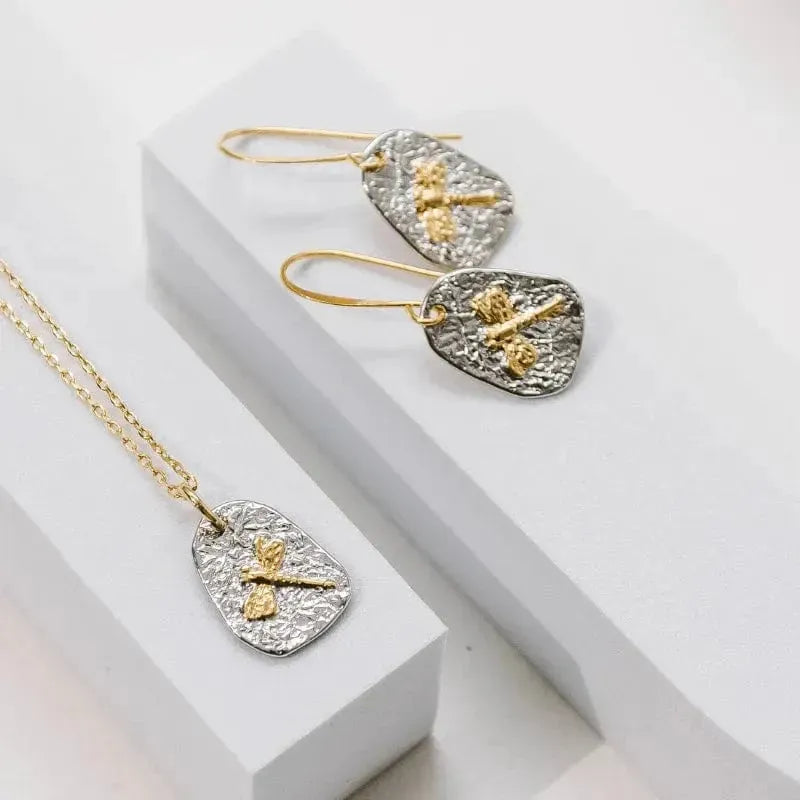 Jewelry set with gold and silver earrings on a white surface