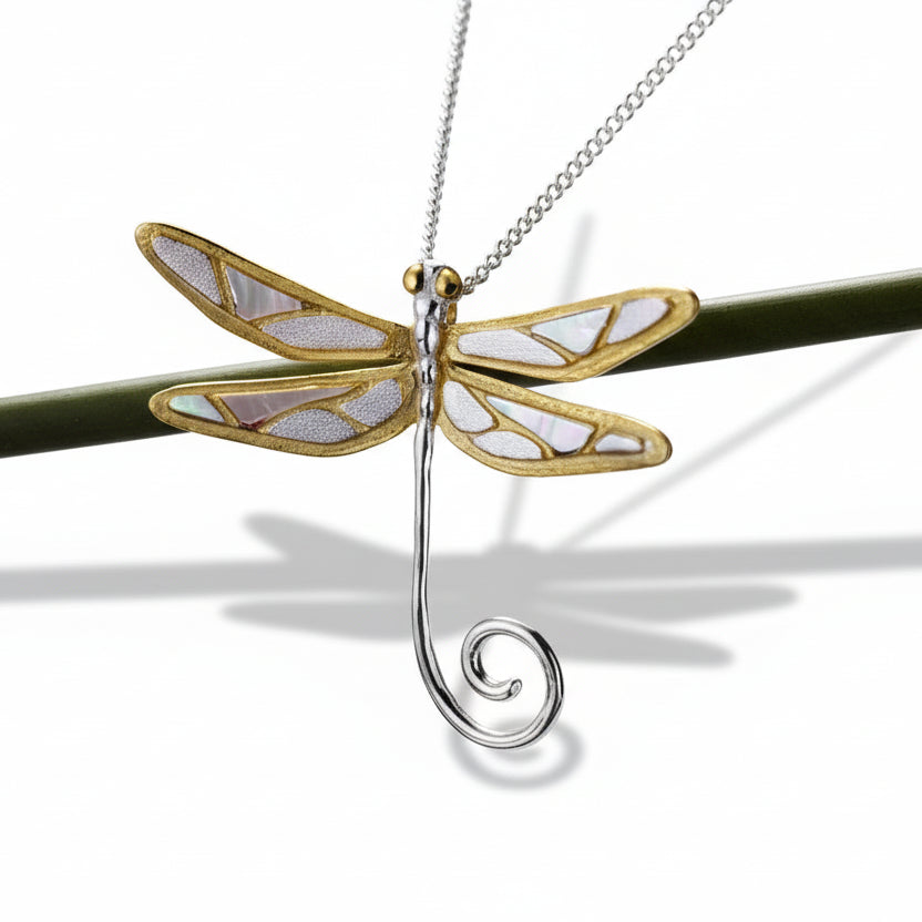 Dragonfly-shaped pendant on a chain against a dark background