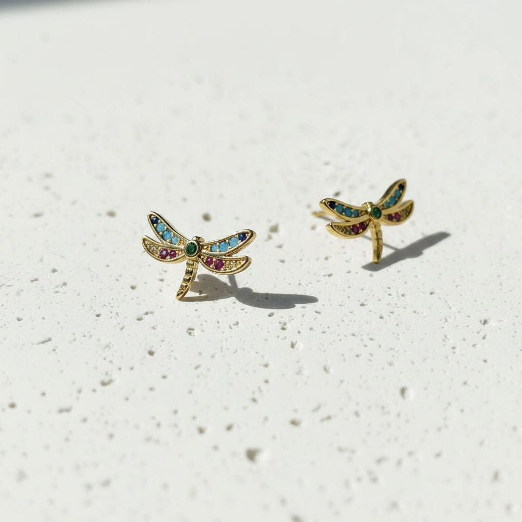 Top-down view of hand-painted dragonfly stud earrings in gold — spirit animal jewelry