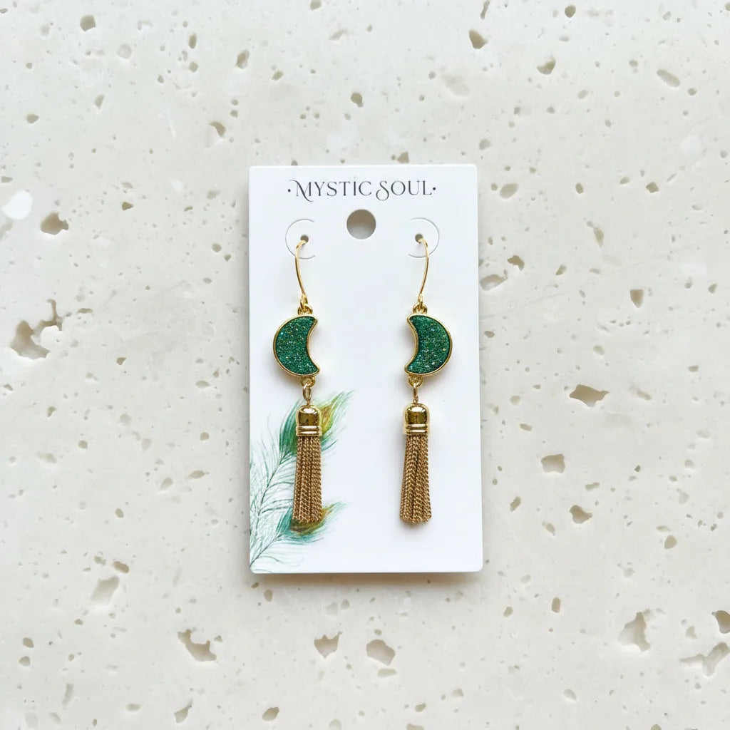 Pair of gold and green earrings on a 'Mystic Soul' card 