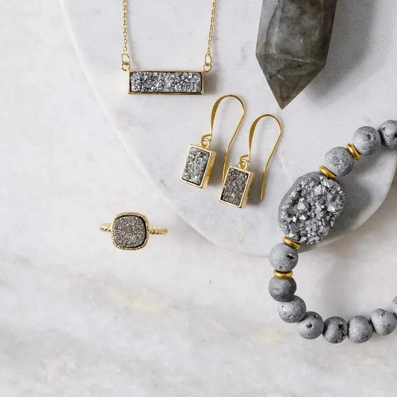 Jewelry set including necklace, earrings, and bracelet on a marble surface