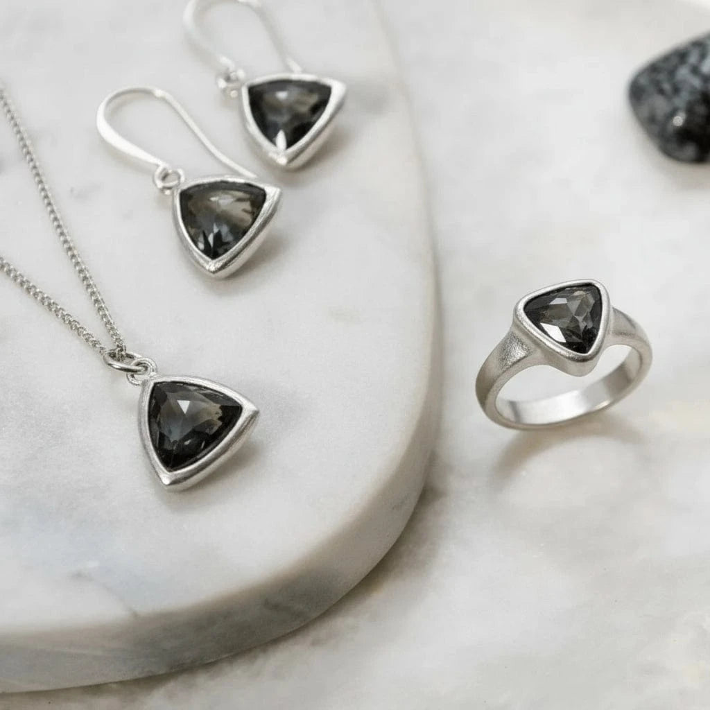Gold jewelry set with gemstones on a marble surface