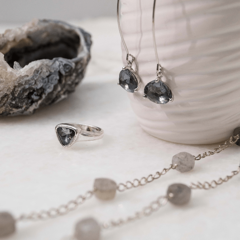 Silver jewelry set with gemstones on a light background