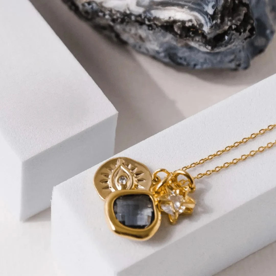 Gold necklace with a pendant on a white surface