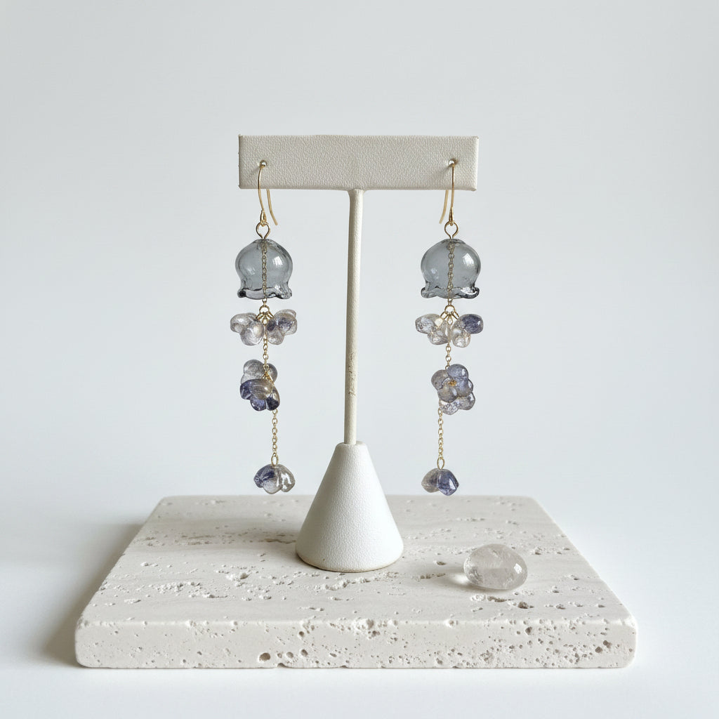 Dusk grey glass jellyfish earrings hanging, close up of the blown glass bell