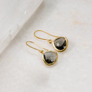 Gold earrings with smoky quartz stones on a light background
