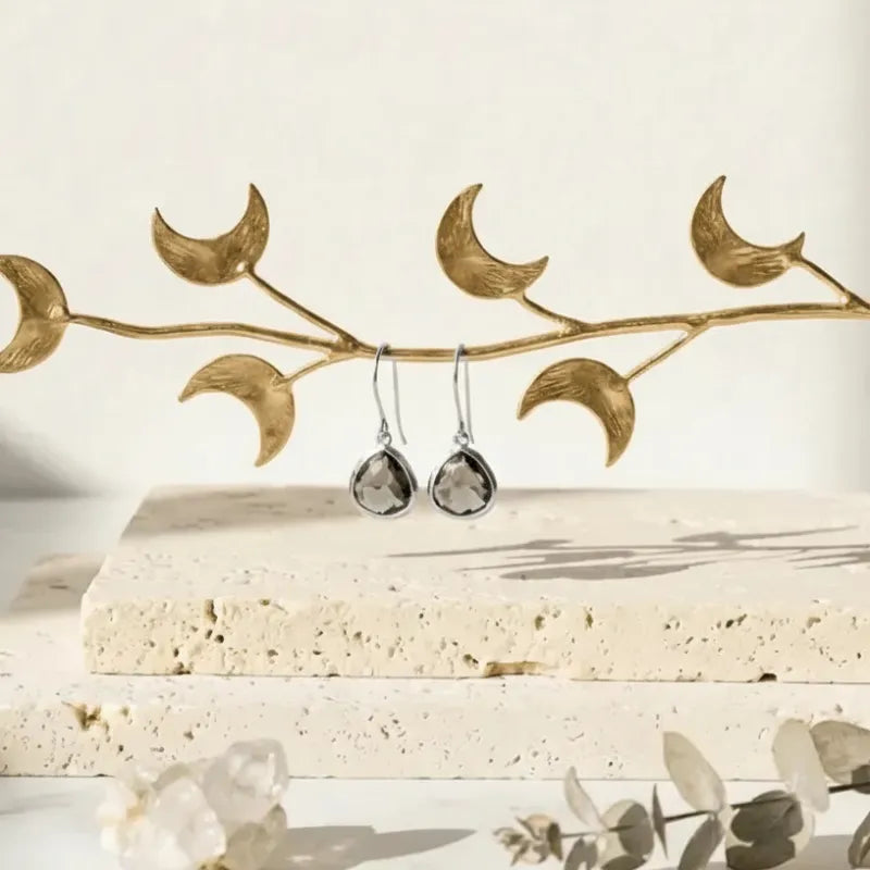 Dusk grey mini drop earrings in gold hanging from a branch, twilight glass teardrop jewelry