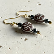 Two-eye dzi bead close up gold plated — etched agate earrings for harmony