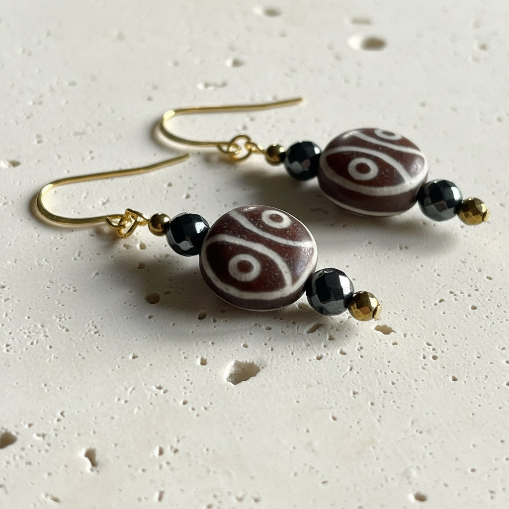 Two-eye dzi bead close up gold plated — etched agate earrings for harmony