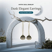 Dusk Elegant Earrings by Mystic Soul Jewelry hanging on a stone arch with a natural background.