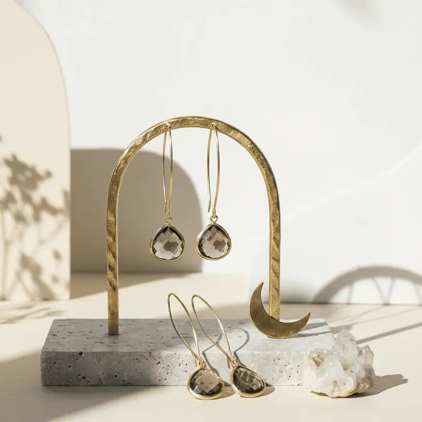 Gold and silver earrings on a stand with 'Best Seller - Elegant Dusk Drops' text.