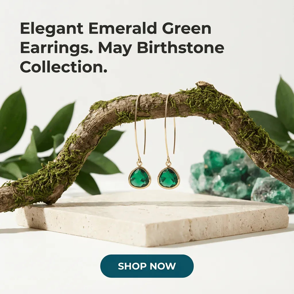 Elegant emerald green earrings on a branch with text about May birthstone collection and a 'Shop Now' button.
