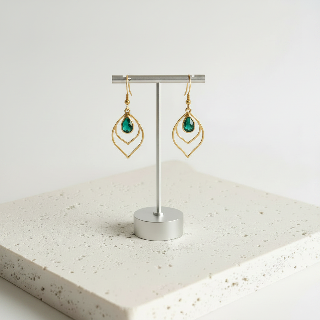 Emerald green faceted glass teardrop earrings in gold, shown hanging