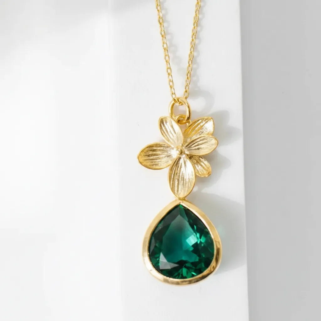 Gold plated orchid glass drop necklace with an emerald green faceted drop