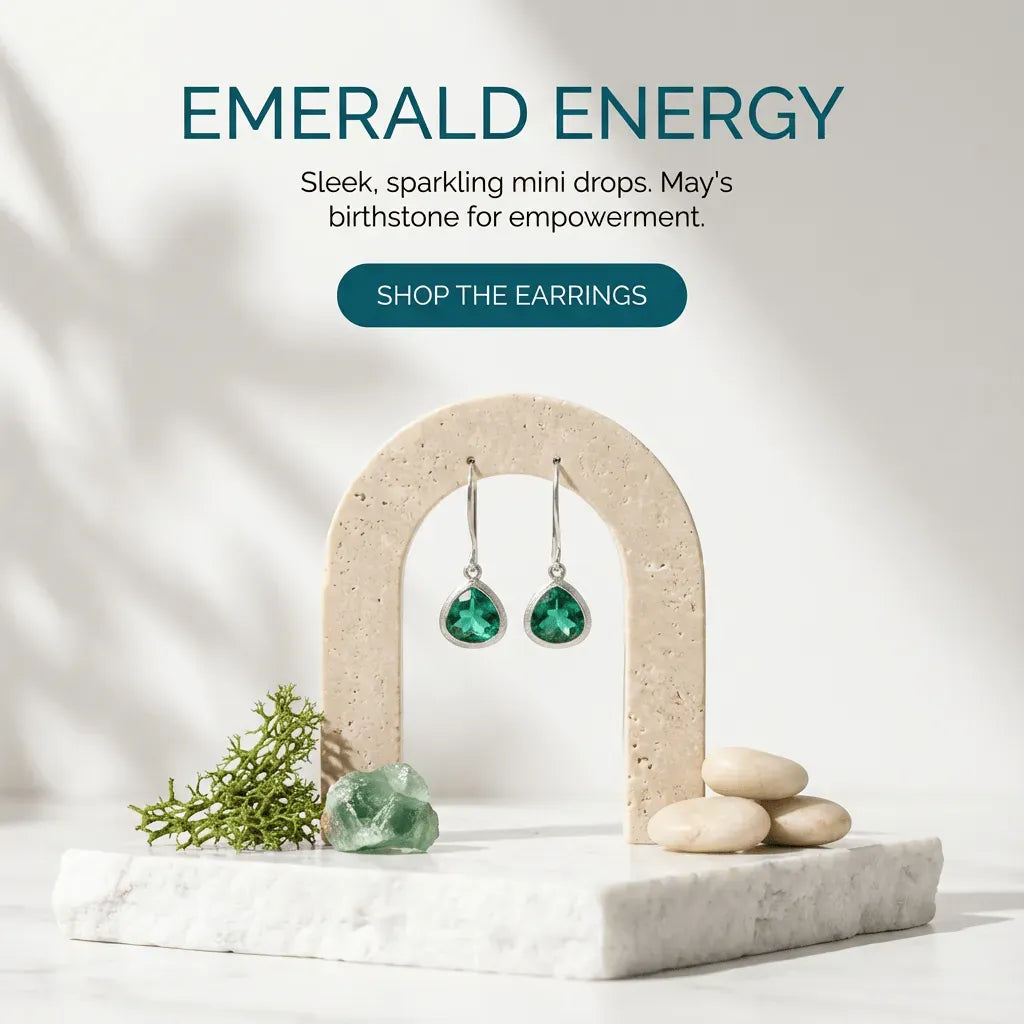Emerald earrings on a stone arch with text about emerald energy and May's birthstone.