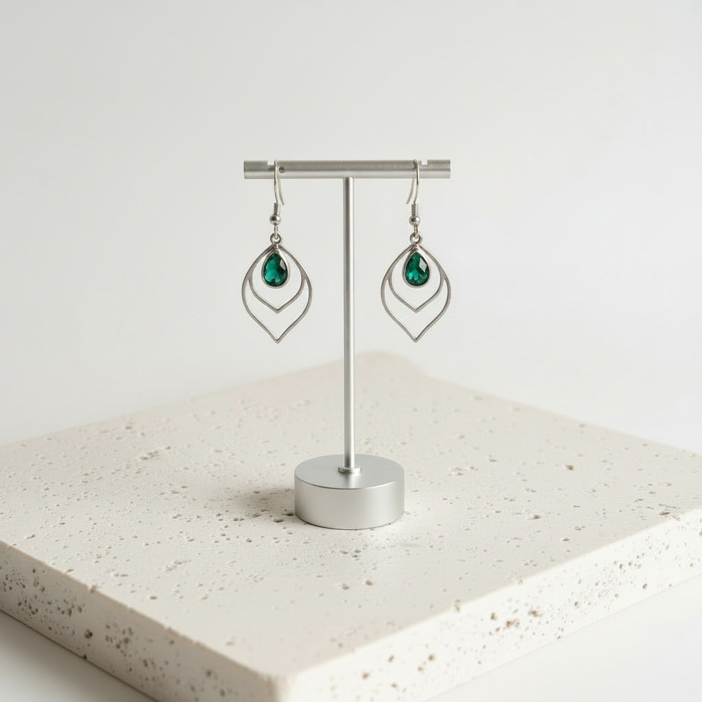 Emerald green faceted glass teardrop earrings in silver, shown hanging