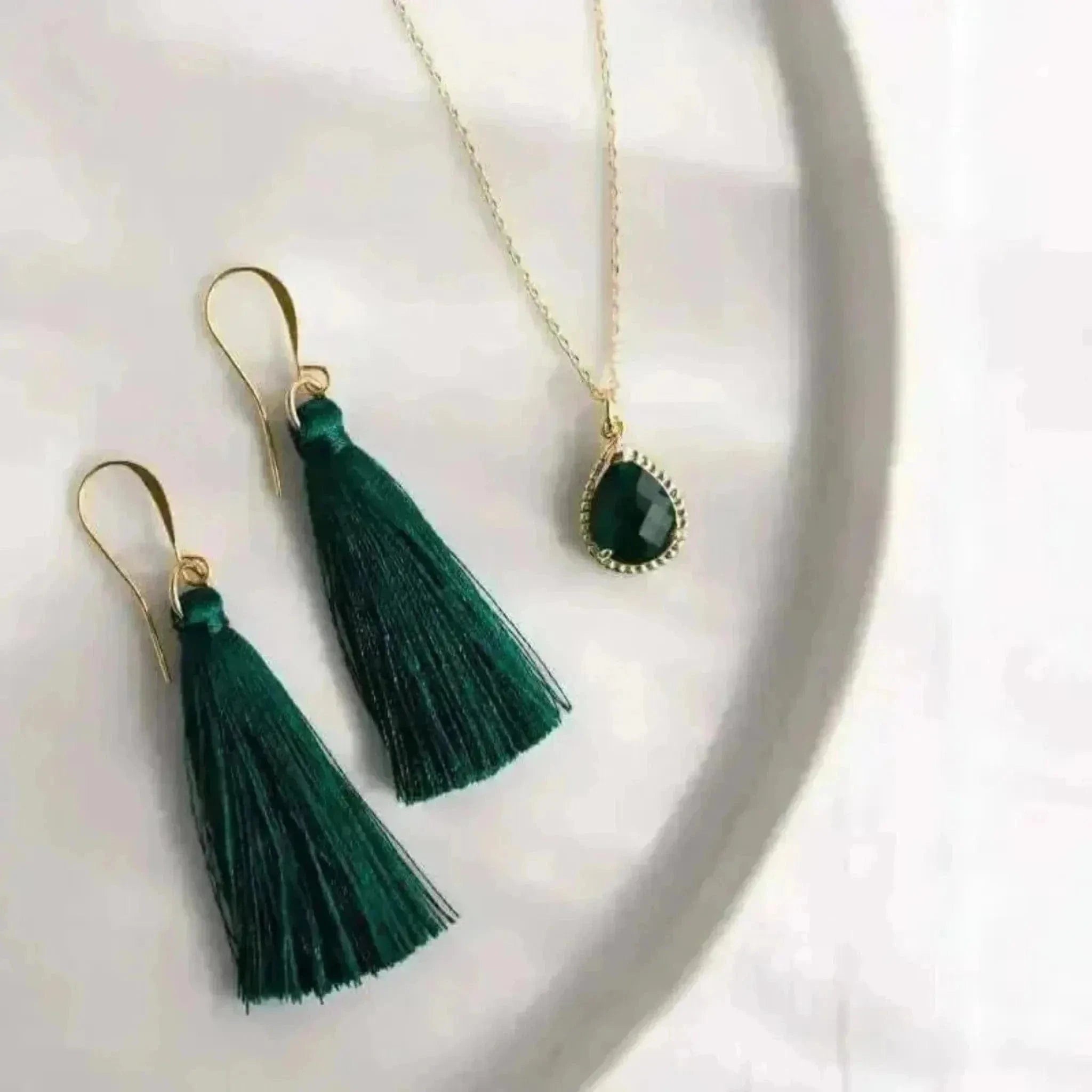 Green tassel earrings and necklace on a white background