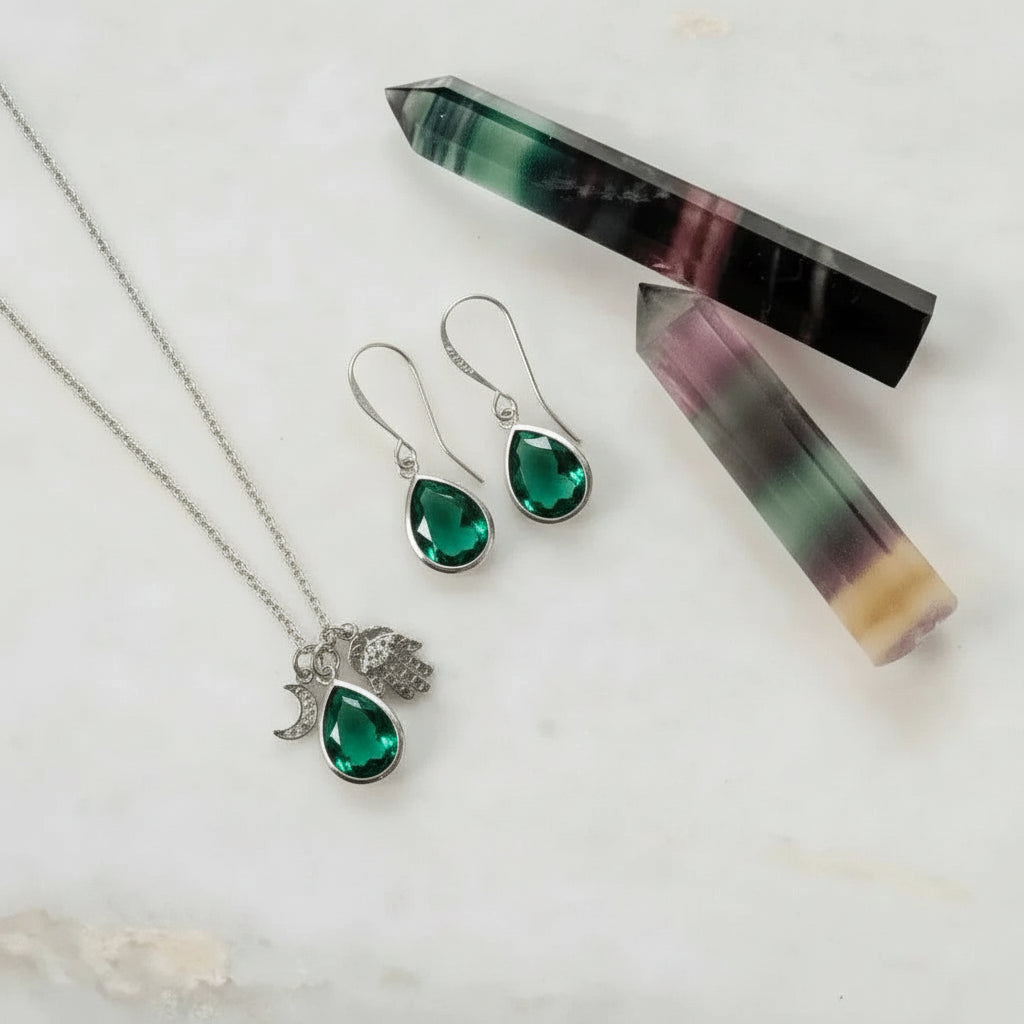 Jewelry set with necklace, earrings, and crystal on a light background