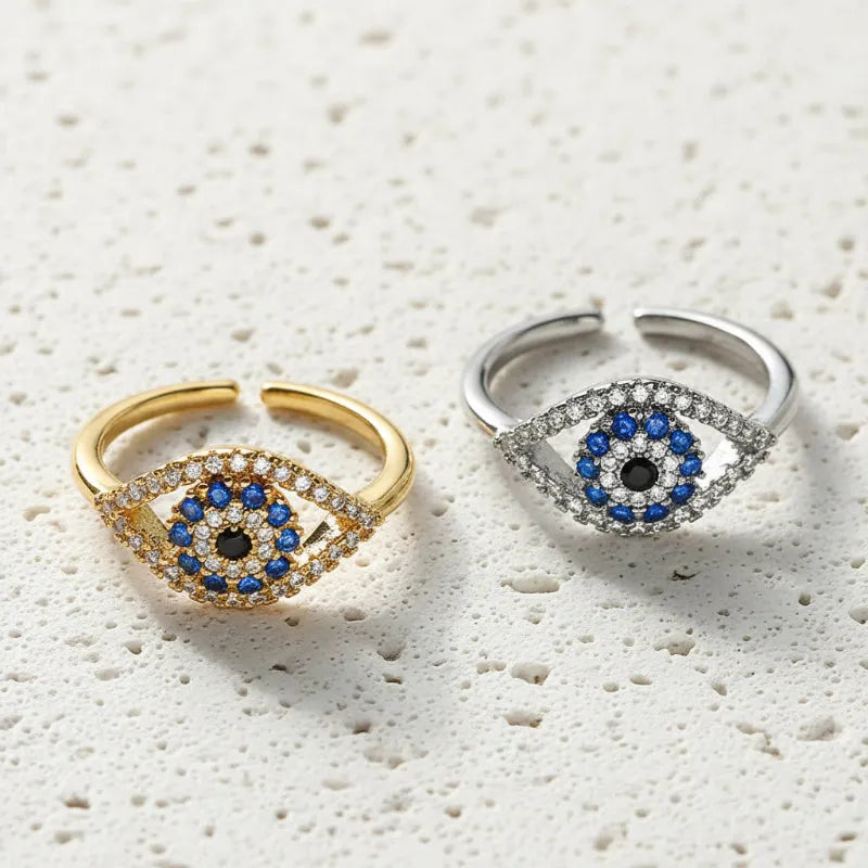 Gold and silver evil eye rings with blue cubic zirconia centres, resizable bands