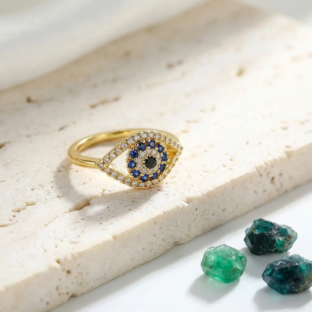 Gold evil eye ring with blue cubic zirconia centre on a resizable band