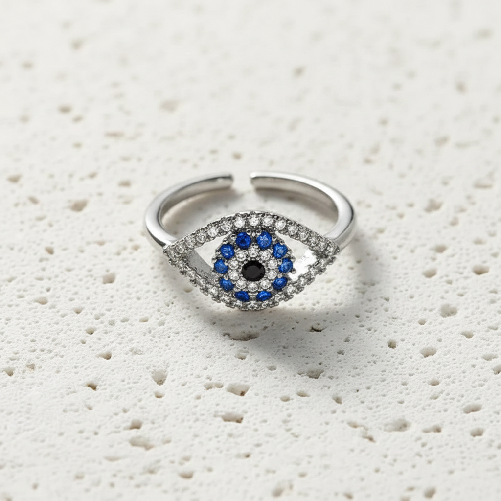 Silver evil eye ring with blue cubic zirconia centre on a resizable band