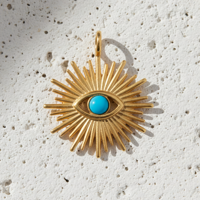 Gold plated evil eye charm with a turquoise centre — symbol of protection