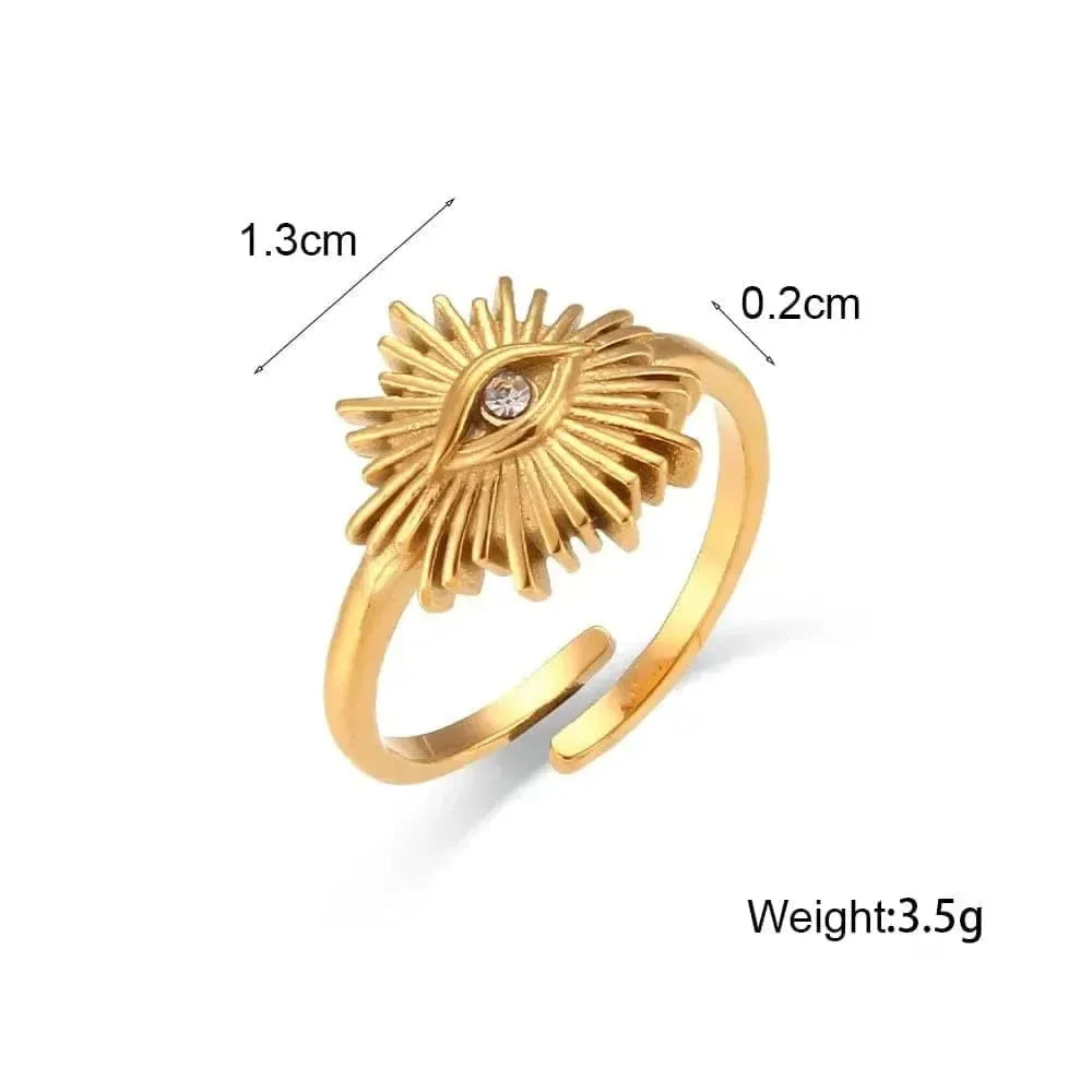 Gold ring with eye design and measurements on a white background
