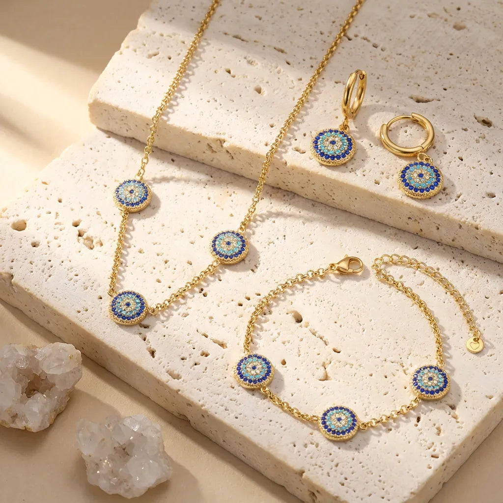 Gold jewelry set with blue and green accents on a textured stone surface