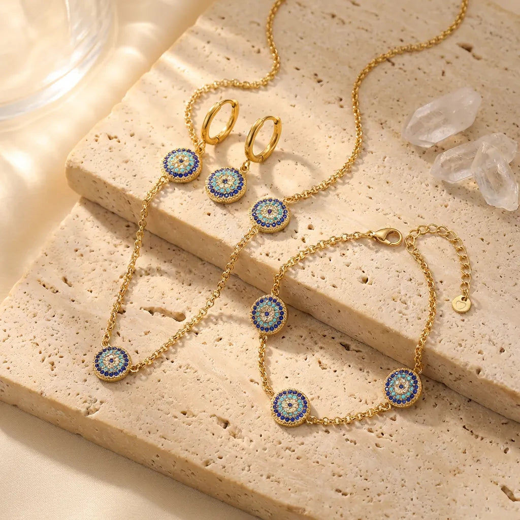 Gold jewelry set with blue and gold accents on a textured surface