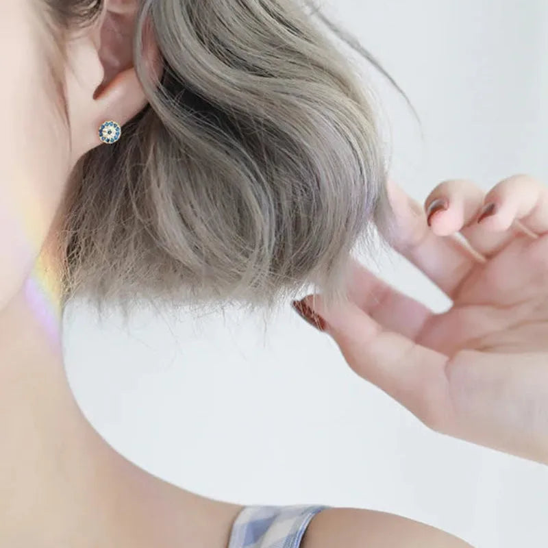 Person with gray hair wearing a white headband, close-up of ear and hand.