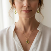 Woman wearing peridot green exquisite necklace and earrings, August birthstone jewelry