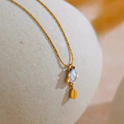 Gold necklace with a pendant on a textured surface