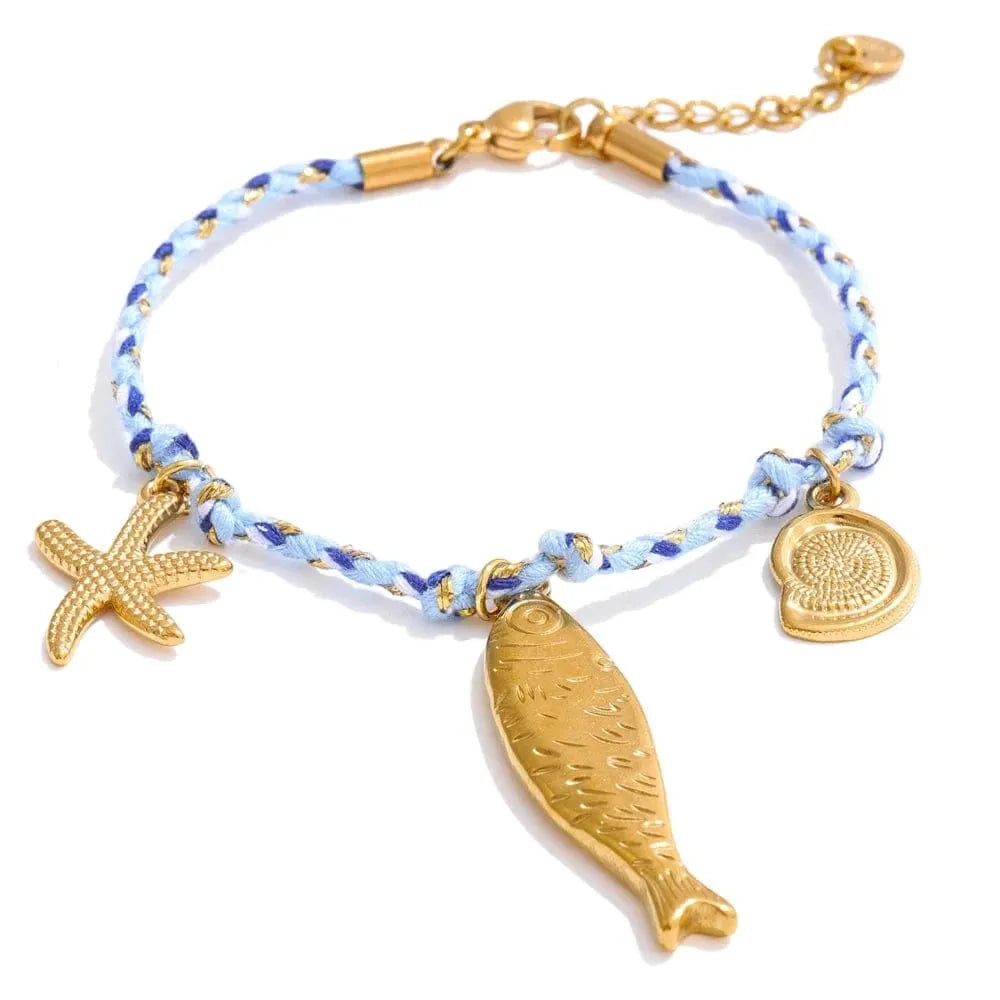 Bracelet with gold fish, starfish, and coin charms on a white background