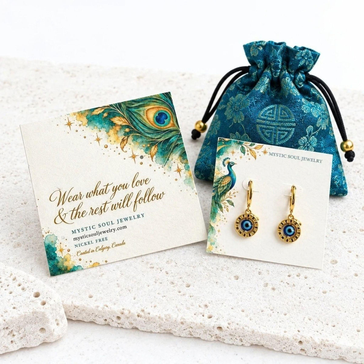 Gold floating evil eye leverback earrings with a teal gift pouch and card