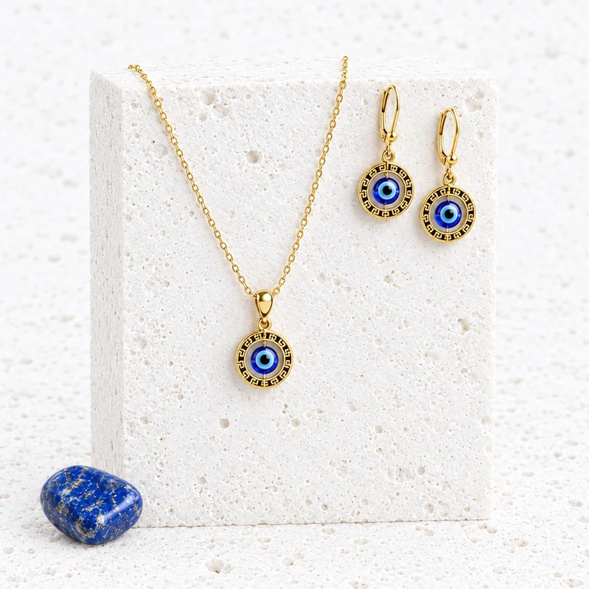 Floating evil eye necklace and leverback earrings set in gold-plated sterling silver on a white stand