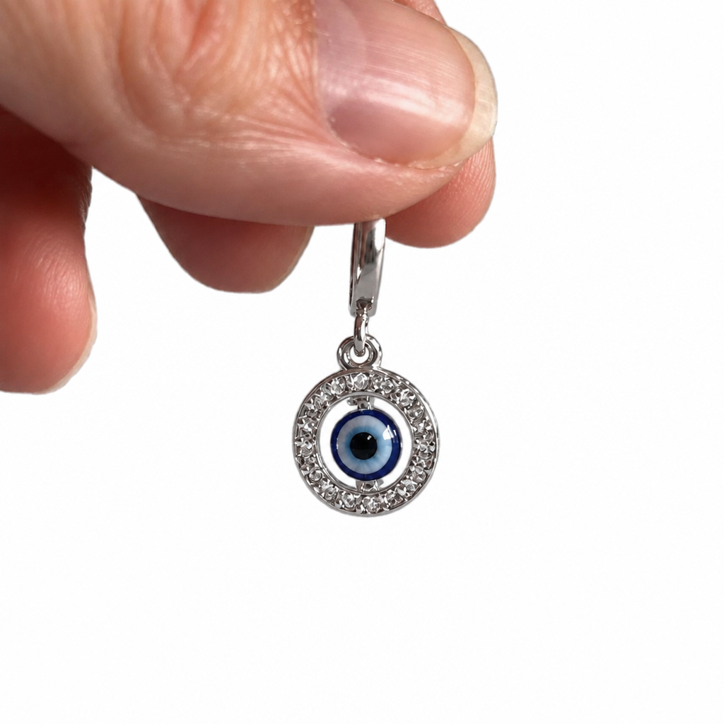 Fingers holding the sterling silver floating evil eye pendant, shown for scale